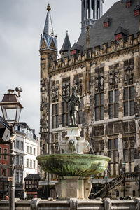 Low angle view of statue and buildings against sky