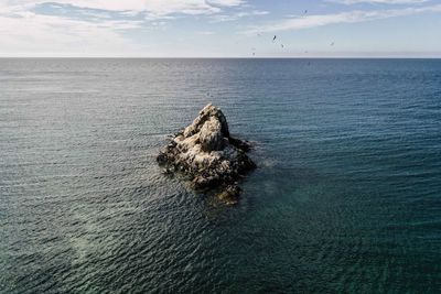 View of rock in sea against sky