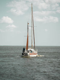 Sailboat sailing on sea against sky