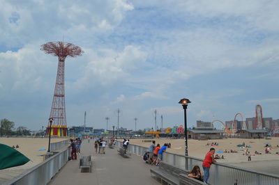Group of people in amusement park against sky in coney island.