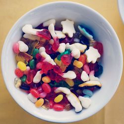 Directly above shot of multi colored candies in bowl on table