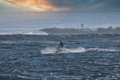 Man surfing in sea against sky