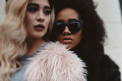 Portrait of woman wearing black sunglasses while standing behind friend