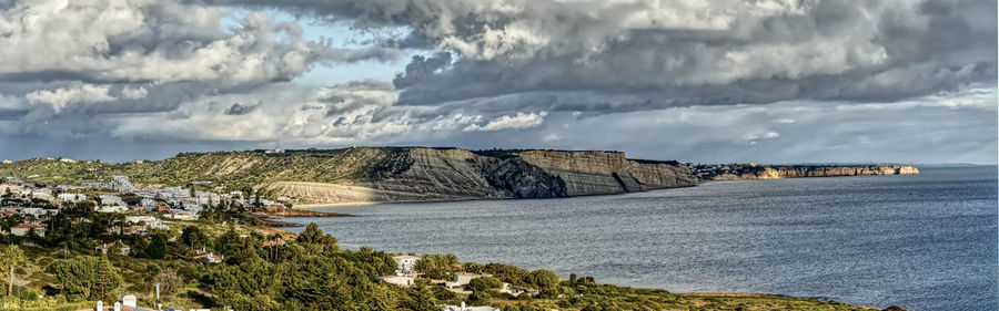 Panoramic view of sea and buildings against sky