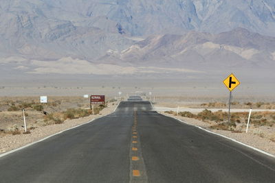 Empty road leading towards mountains
