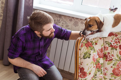 Man with dog sitting at home