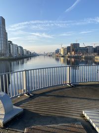 Pier over river in city against sky