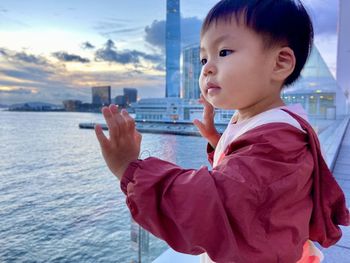 Side view of boy looking at sea against sky