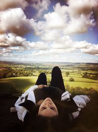 Low section of woman relaxing against sky