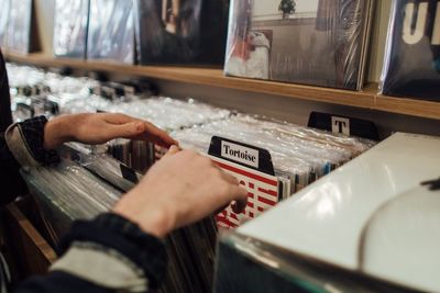 Cropped image of person choosing records in store