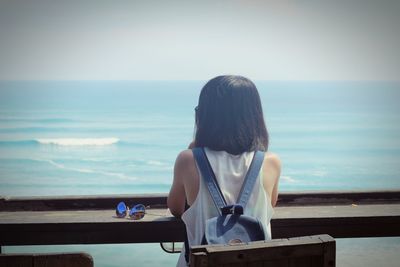 Rear view of woman looking at sea against sky