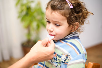 Close-up of girl eating food at home