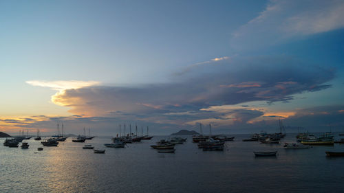 Boats in calm sea at sunset