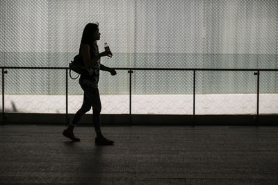 Side view of mid adult woman walking in corridor