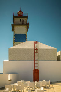 Low angle view of lighthouse tower against clear blue sky