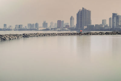 Sea and buildings against clear sky