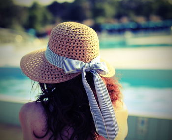 Rear view of woman wearing hat looking at sea