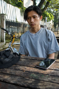 Portrait of young man sitting on table