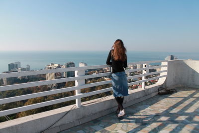 Rear view of woman looking at sea against sky