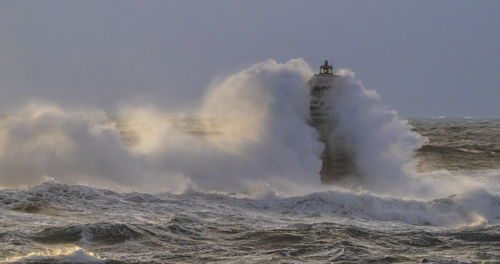 Water splashing in sea against clear sky