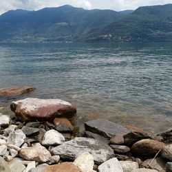 Stones in sea by mountains