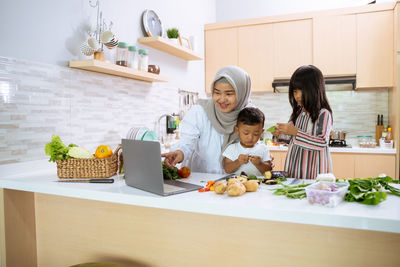 High angle view of girl having food at kitchen