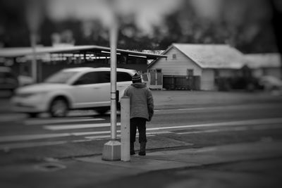 Rear view of man walking on street in city