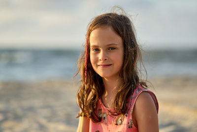 Portrait of a happy little girl on the beach during sunset