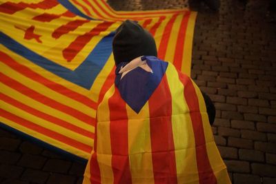 Rear view of man standing against multi colored umbrella