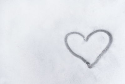Close-up of heart shape on snow