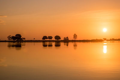 Scenic view of lake against orange sky