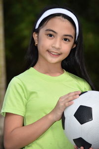 Portrait of smiling girl holding soccer ball