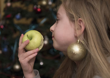 Close-up of young woman eating green apple