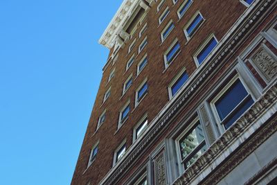 Low angle view of buildings against clear blue sky