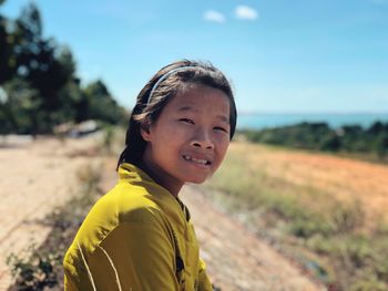 Portrait of teenage girl sitting on field