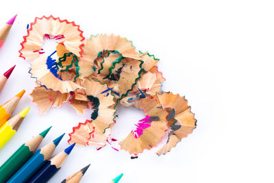 High angle view of multi colored pencils against white background