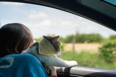 Midsection of woman by car against sky