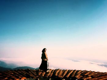 Full length of woman standing on observation point against sky during sunset