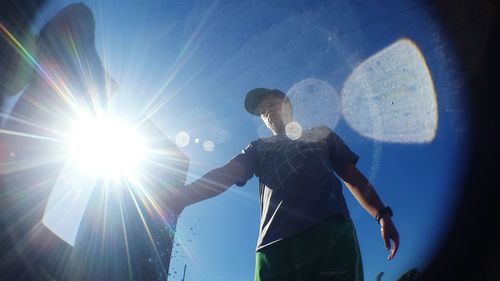 Low angle view of boy playing at park on sunny day