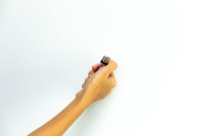 Close-up of hand holding leaf over white background