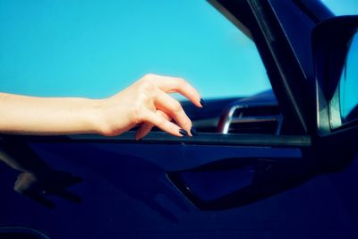 Hand of woman on window of car
