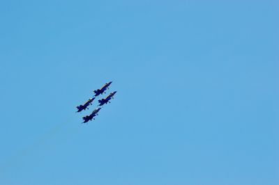 Low angle view of airplane against clear blue sky