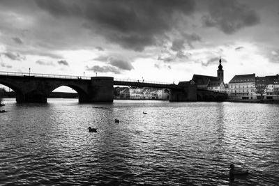 Bridge over river against cloudy sky