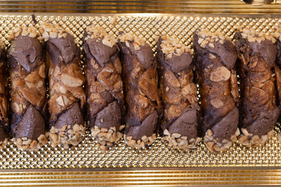 Italian sweet dessert, traditional sicilian cannoli with nuts and chocolate cream seen from above.