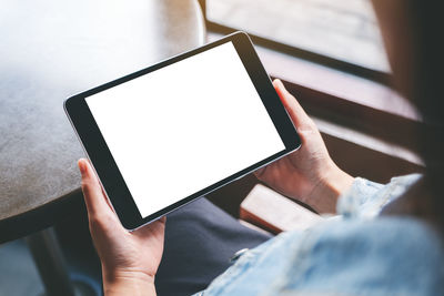 Cropped image of woman using digital tablet