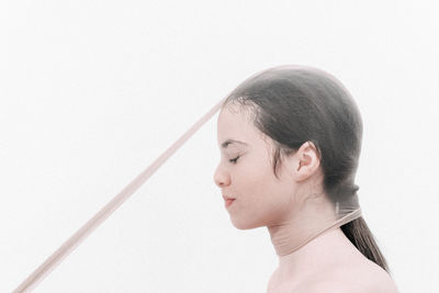 Close-up of woman covered net against white background