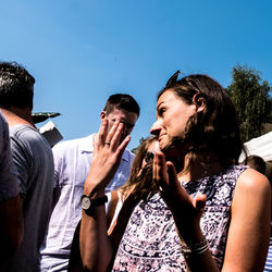 Young couple standing against sky