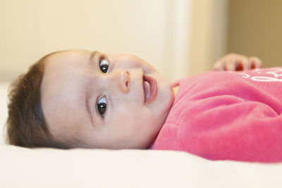 Portrait of cute boy lying on bed at home