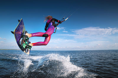 Professional kiter performs a difficult trick on a beautiful background with splashes of water from