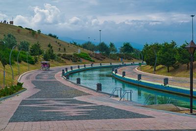 View of swimming pool against cloudy sky